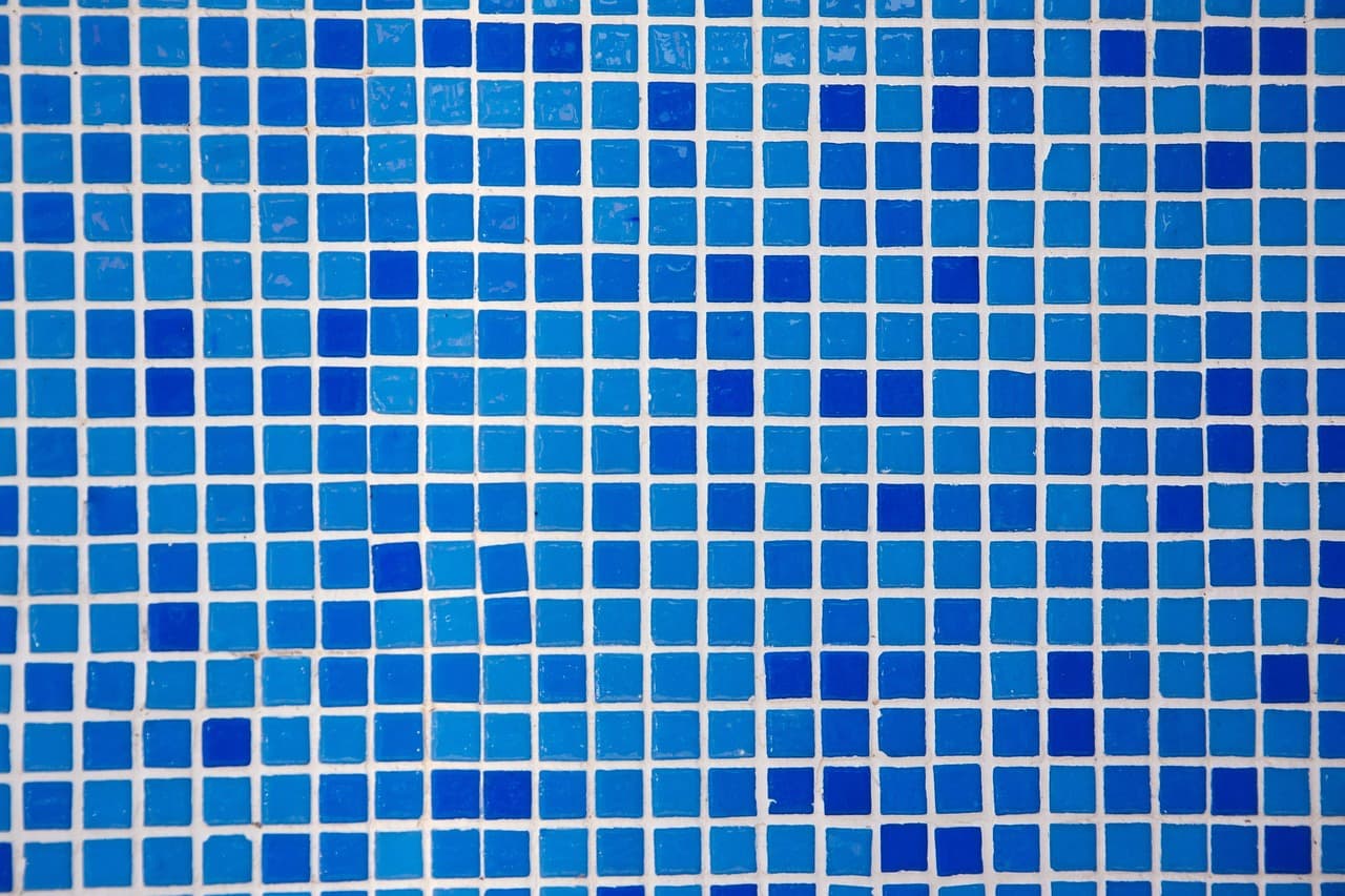 Close detail of deep blue glass mosaic tiles laid in a fine grid